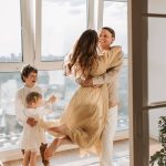 A joyful family embraces in a sunlit modern apartment, celebrating togetherness and love.